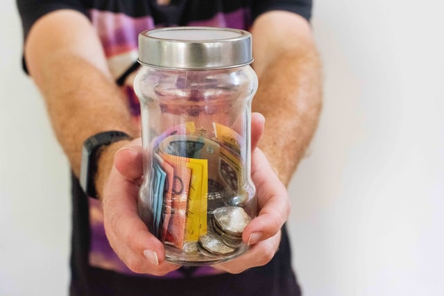 Photo of someone holding a jar of money
